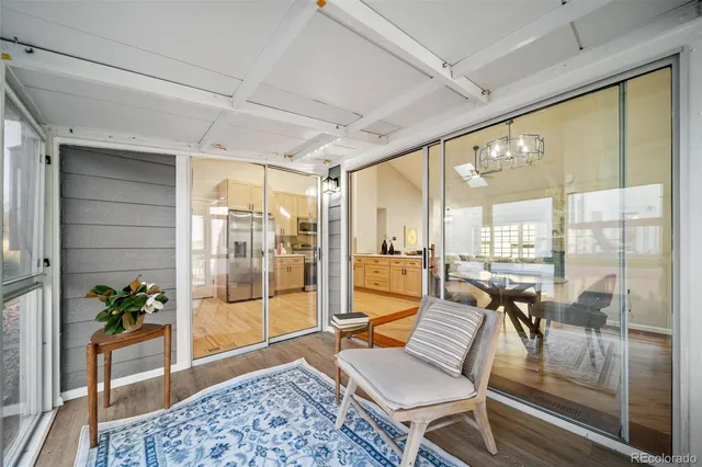 a living room with patio furniture and a potted plant