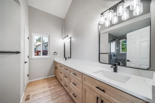 a bathroom with a double vanity sink a mirror and shower