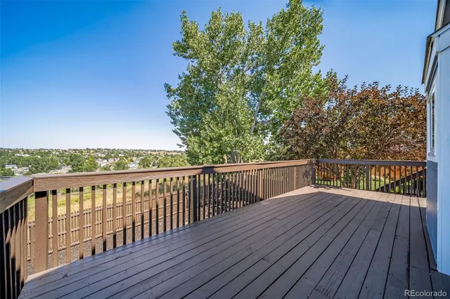 a view of balcony with wooden floor and fence