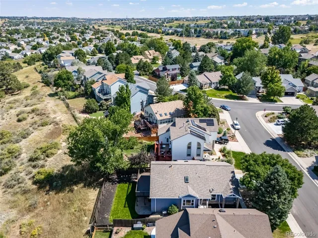 an aerial view of residential houses with outdoor space and trees