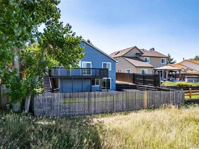 a view of a house with a wooden fence