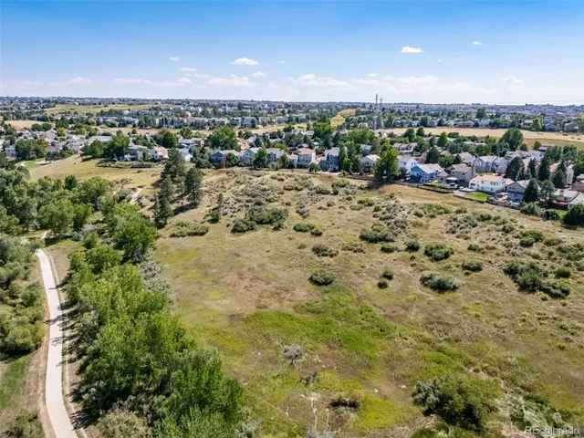 an aerial view of residential houses with outdoor space and trees