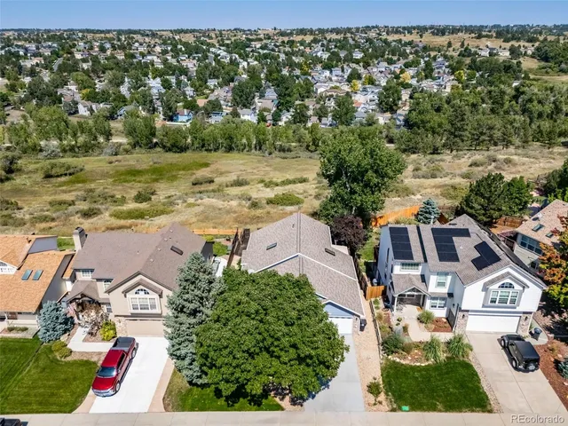 an aerial view of residential houses with outdoor space and trees