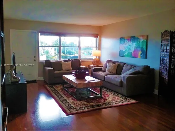 a living room with furniture rug and wooden floor
