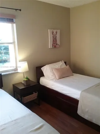 a bedroom with a large bed and a lamp next to a window