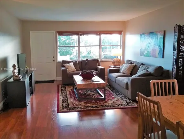 a living room with furniture wooden floor and a large window