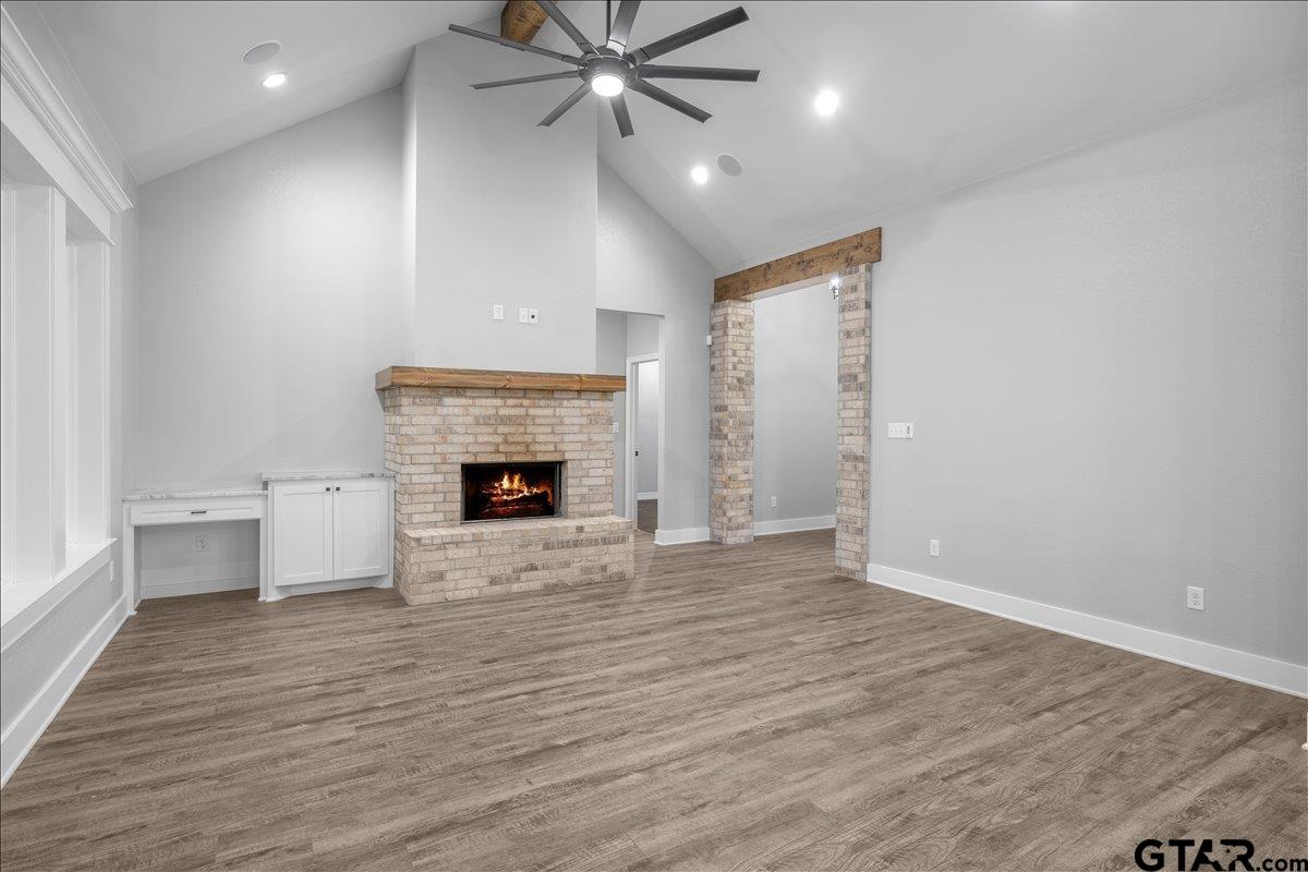 14544 Fallow Lane Lindale, TX 75706 - Photo 11 of 46 an empty room with wooden floor fireplace and windows