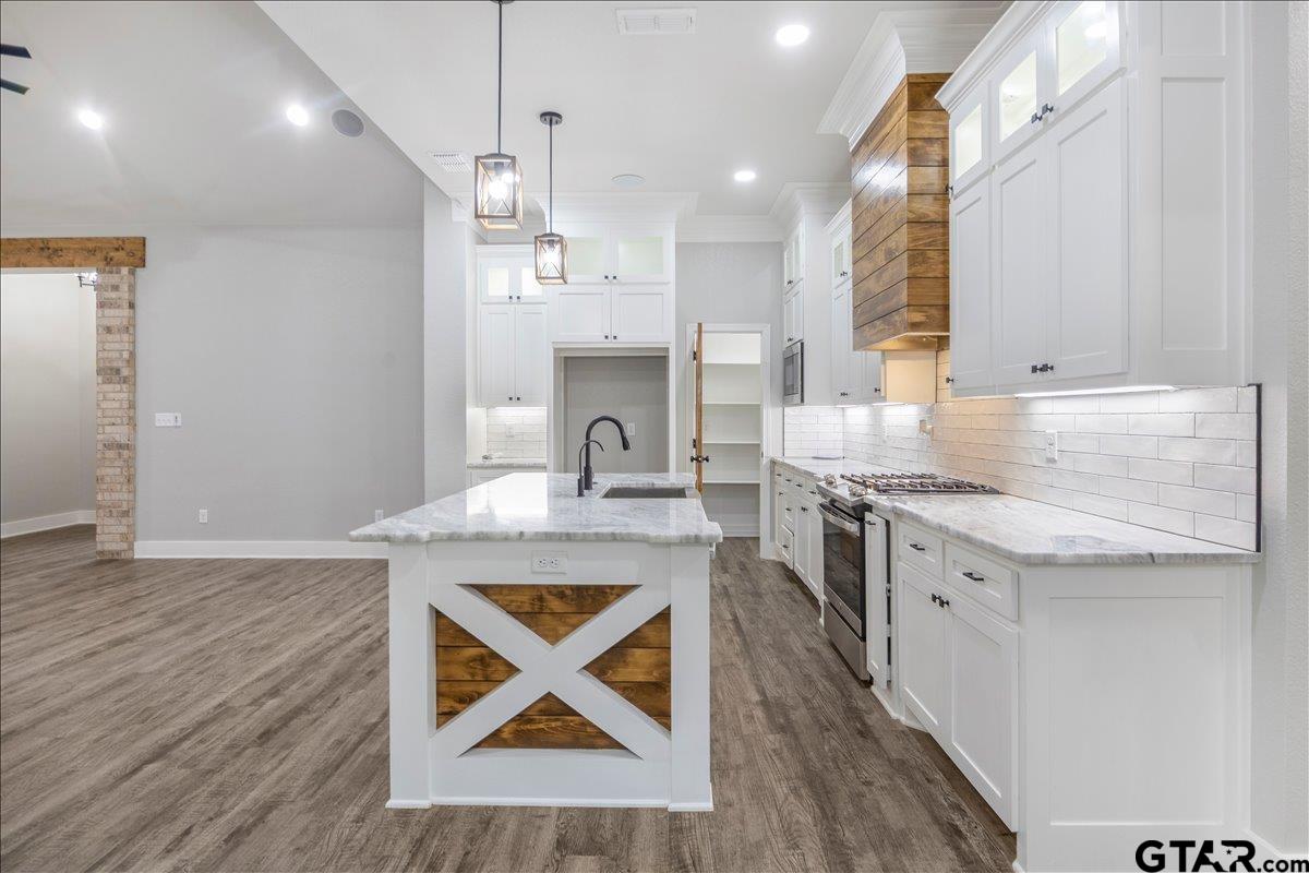 14544 Fallow Lane Lindale, TX 75706 - Photo 12 of 46 a kitchen with stainless steel appliances granite countertop a sink stove and wooden floor