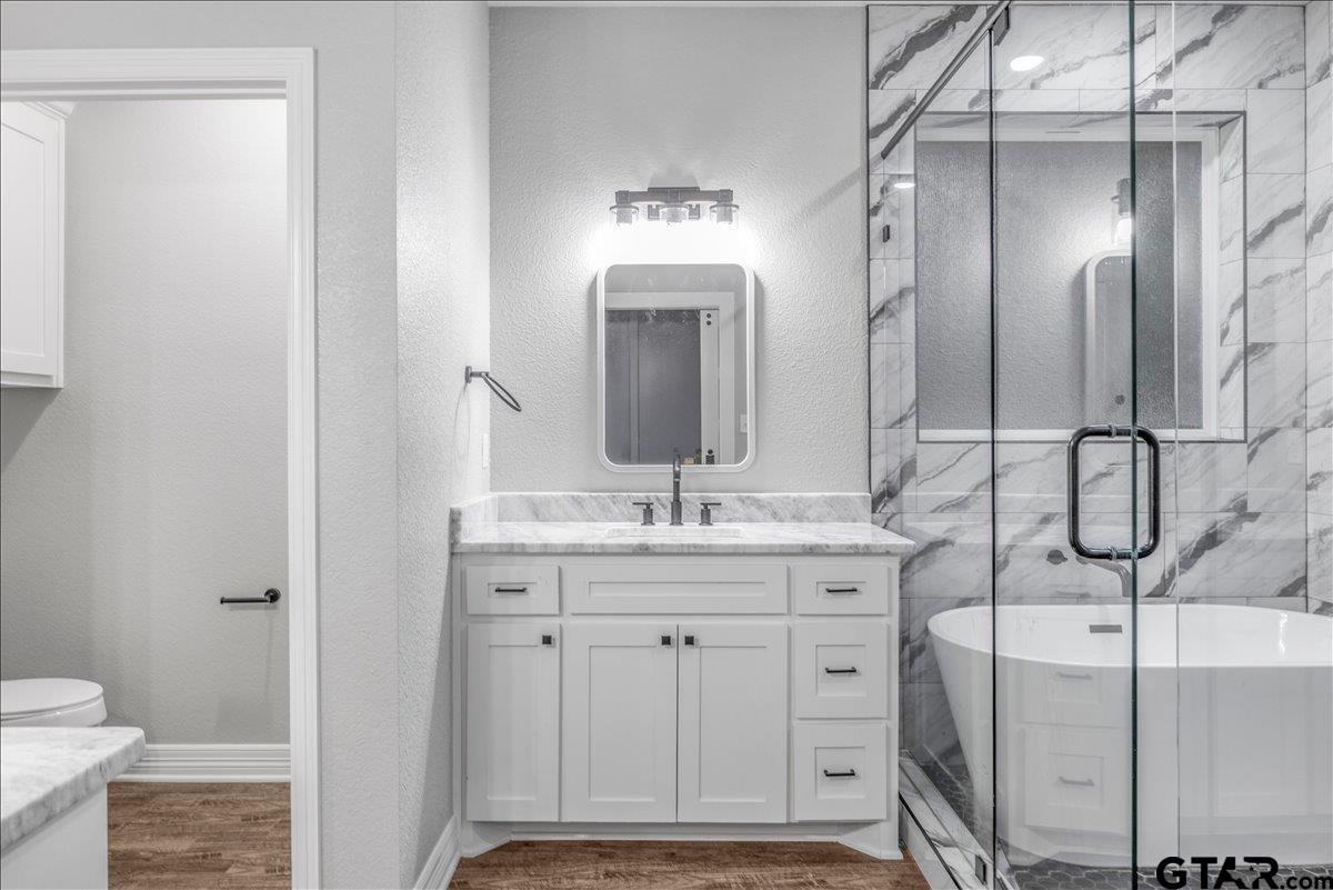 14544 Fallow Lane Lindale, TX 75706 - Photo 23 of 46 a bathroom with a granite countertop sink a toilet and a mirror