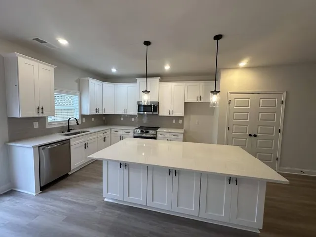 a large kitchen with a large counter top appliances and cabinets