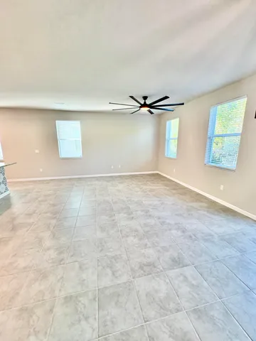 en empty room with windows and ceiling fan
