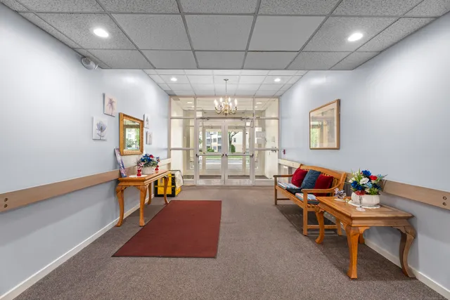 a living room with furniture a flat screen tv and a large window