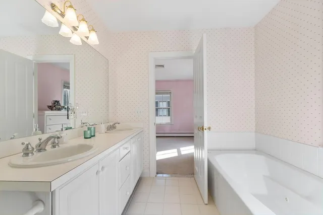 a bathroom with a tub a sink and mirror