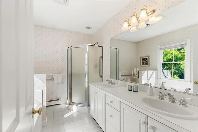 a bathroom with double vanity sink a two mirror a window and a shower