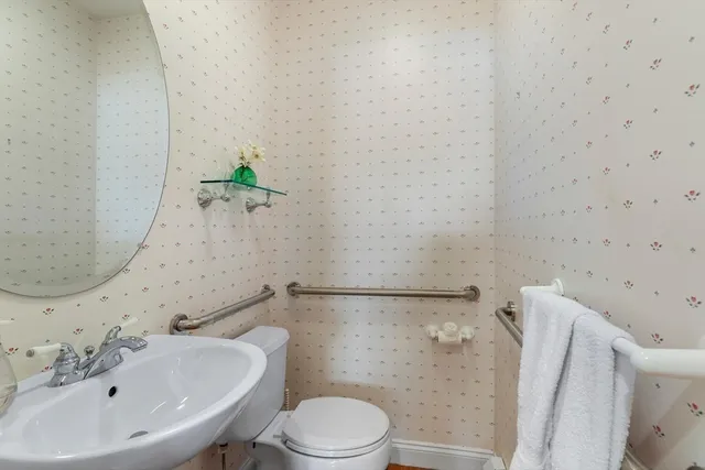 a white toilet sitting next to a bathroom sink