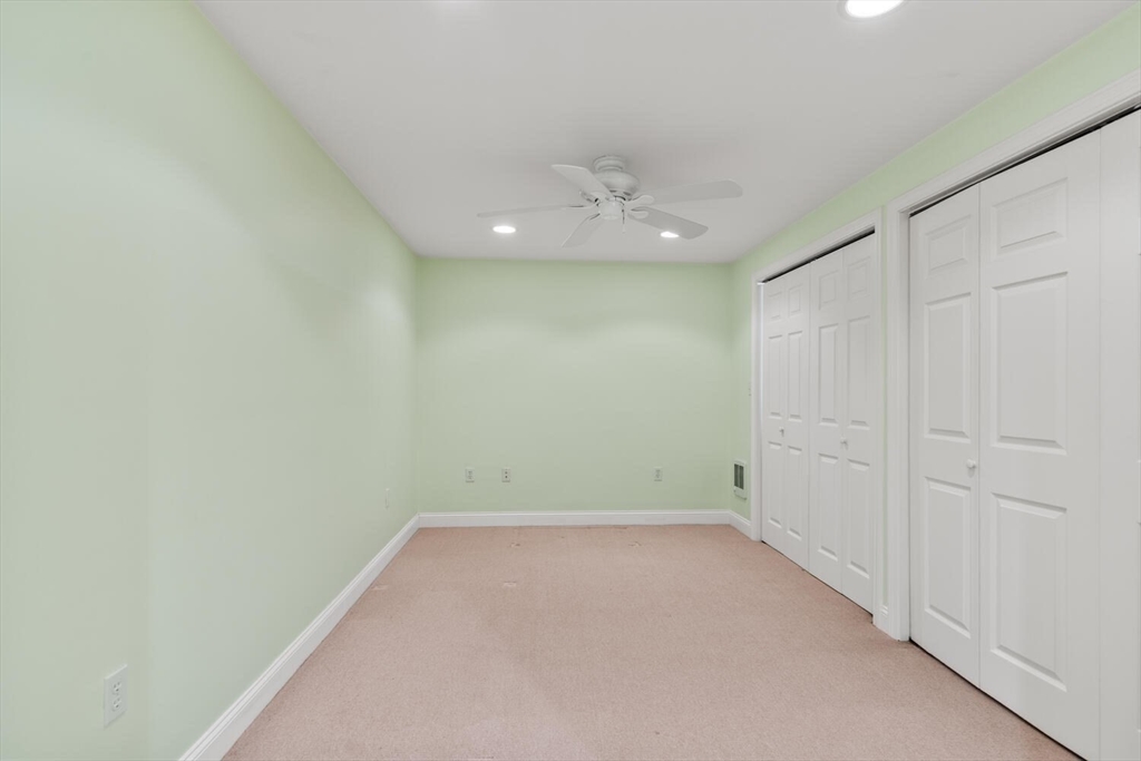 56 Brook Street, Unit B Manchester, MA 01944 - Photo 34 of 37 an empty room with a ceiling fan and carpet