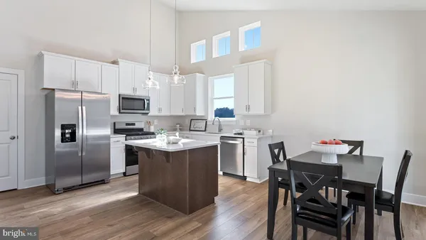 a kitchen with a table chairs refrigerator and microwave