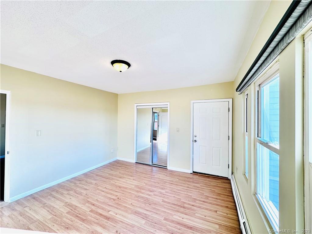 398 Park Street, Unit 3 New Britain, CT 06051 - Photo 1 of 17 a view of an empty room with wooden floor and a window