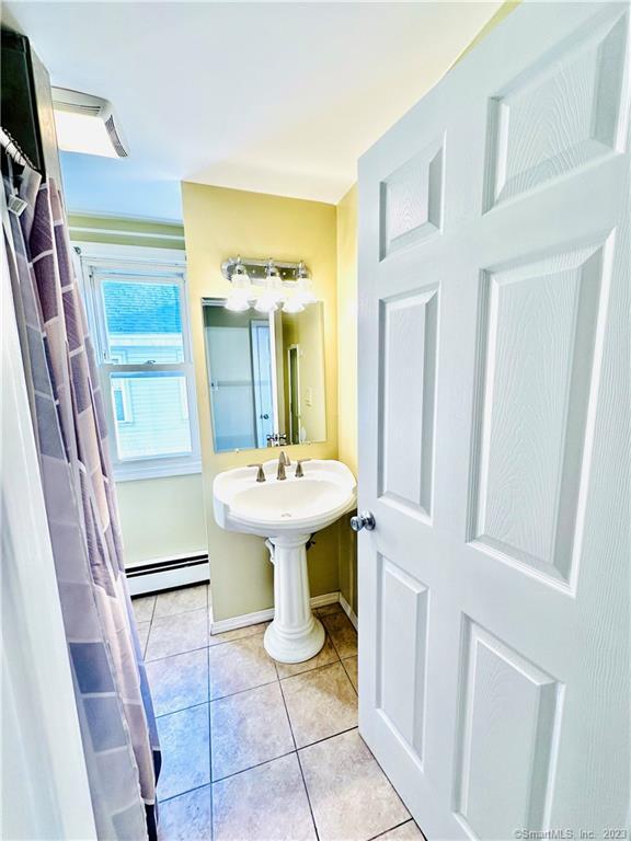 398 Park Street, Unit 3 New Britain, CT 06051 - Photo 9 of 17 a bathroom with a sink a toilet and mirror