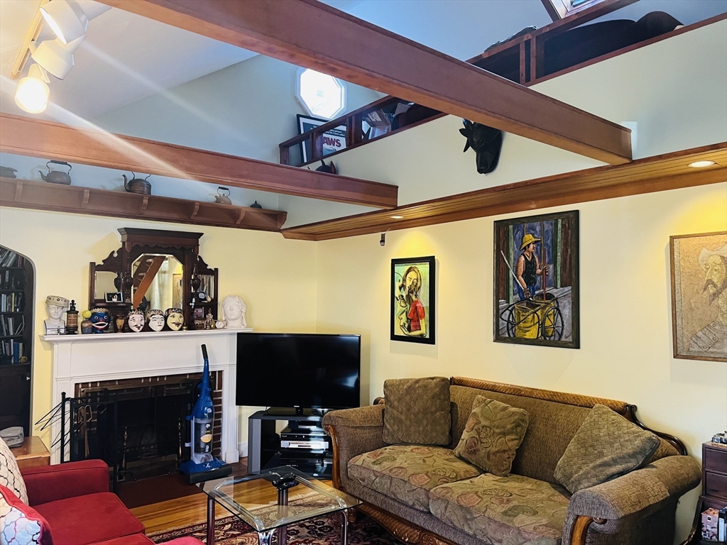 137 Warwick Road, Unit 137 Newton, MA 02465 - Photo 2 of 8 a living room with furniture a flat screen tv and a fireplace