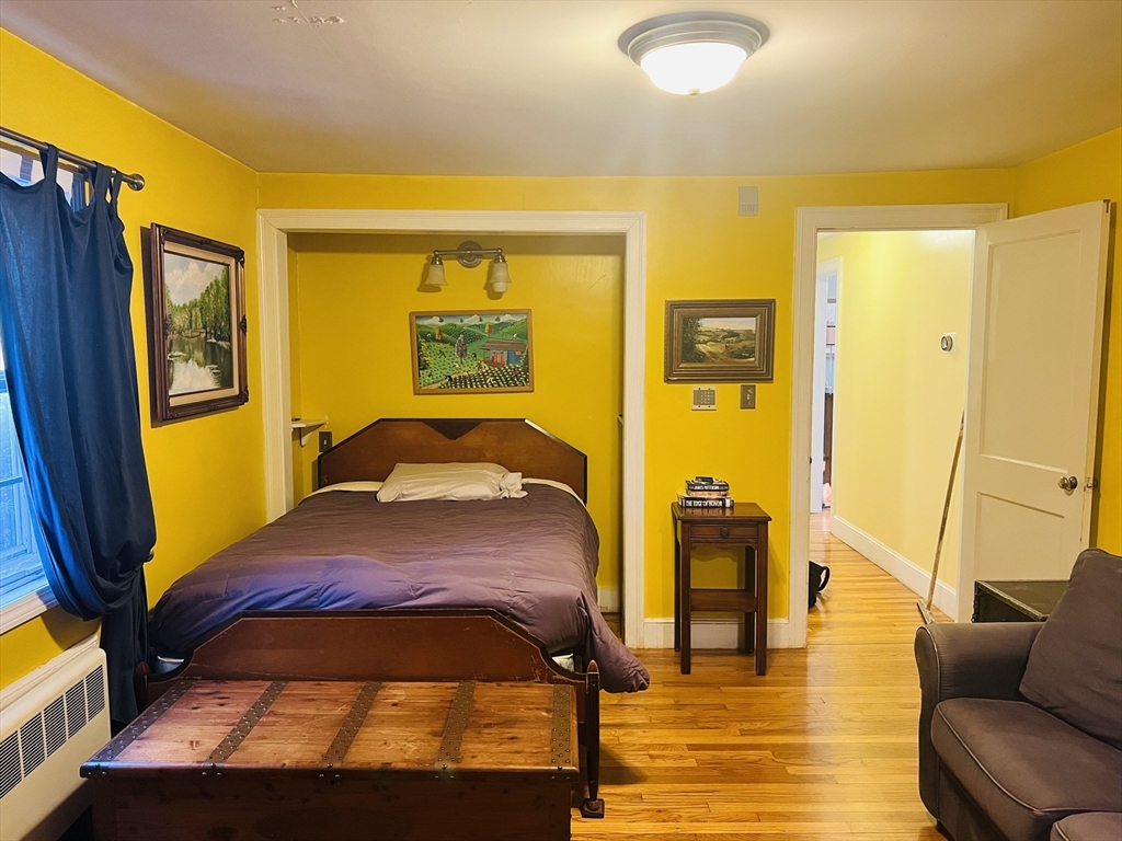 137 Warwick Road, Unit 137 Newton, MA 02465 - Photo 4 of 8 a bedroom with a bed and wooden floor