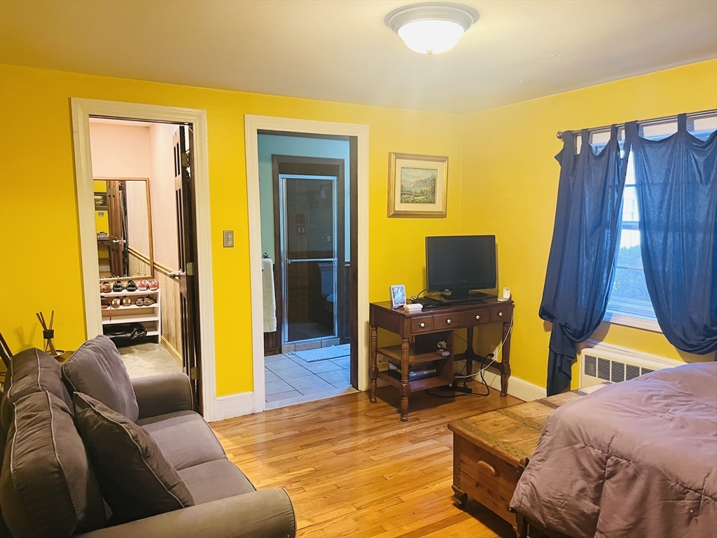 137 Warwick Road, Unit 137 Newton, MA 02465 - Photo 5 of 8 a bedroom with a bed and wooden floor