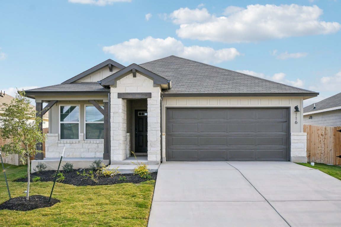 116 Honey Bee Road Jarrell, TX 76537 - Photo 1 of 1 View of front of house featuring stone siding, concrete driveway, an attached garage, and a shingled roof