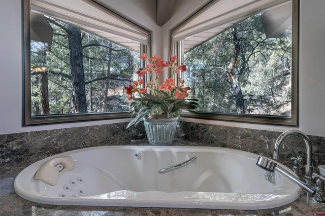 a bathroom with a tub sink and mirror