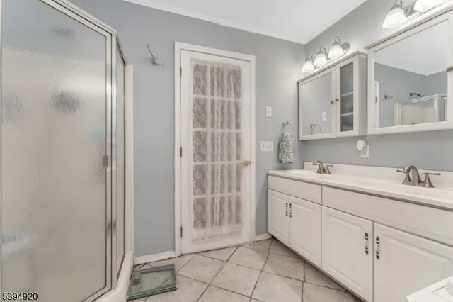 a bathroom with a double vanity sink a mirror and a shower