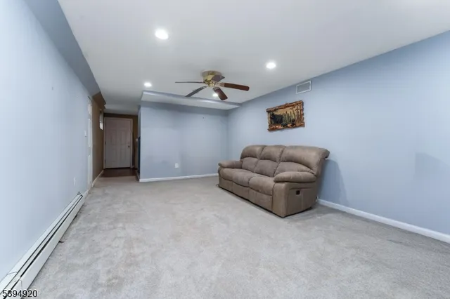 a living room with furniture and a ceiling fan