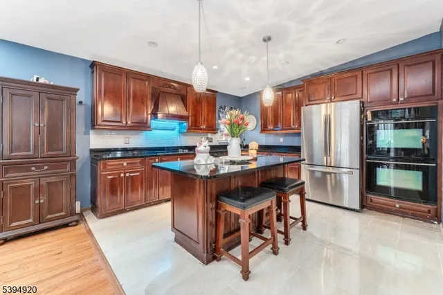 a kitchen with stainless steel appliances granite countertop a stove refrigerator and cabinets