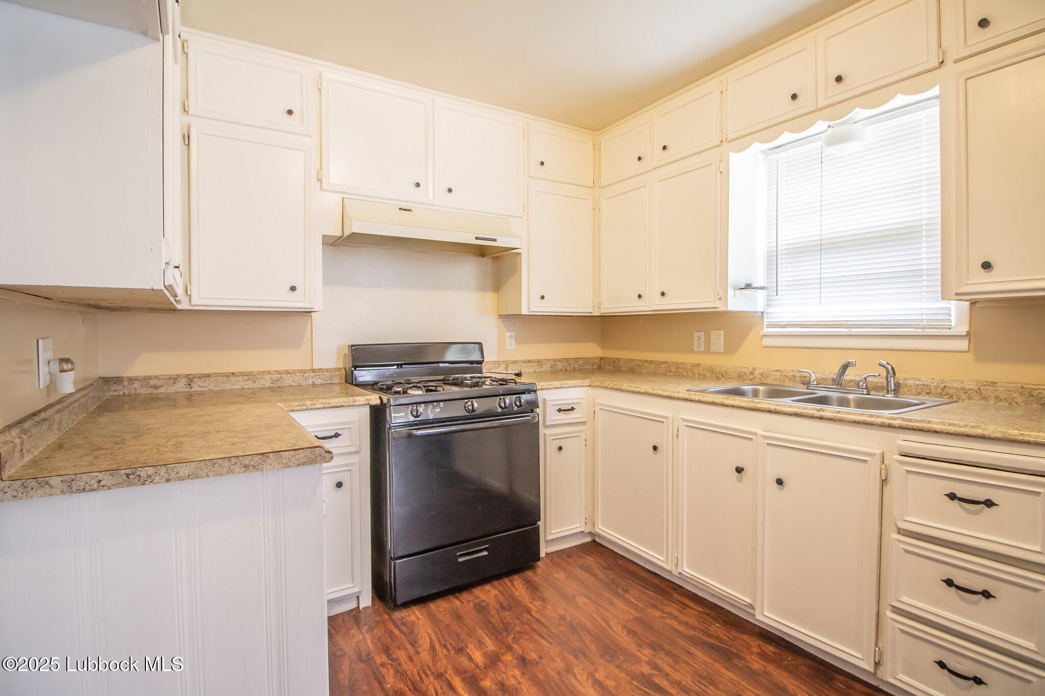 2414 38th Street Lubbock, TX 79412 - Photo 9 of 20 a kitchen with granite countertop white cabinets and white appliances