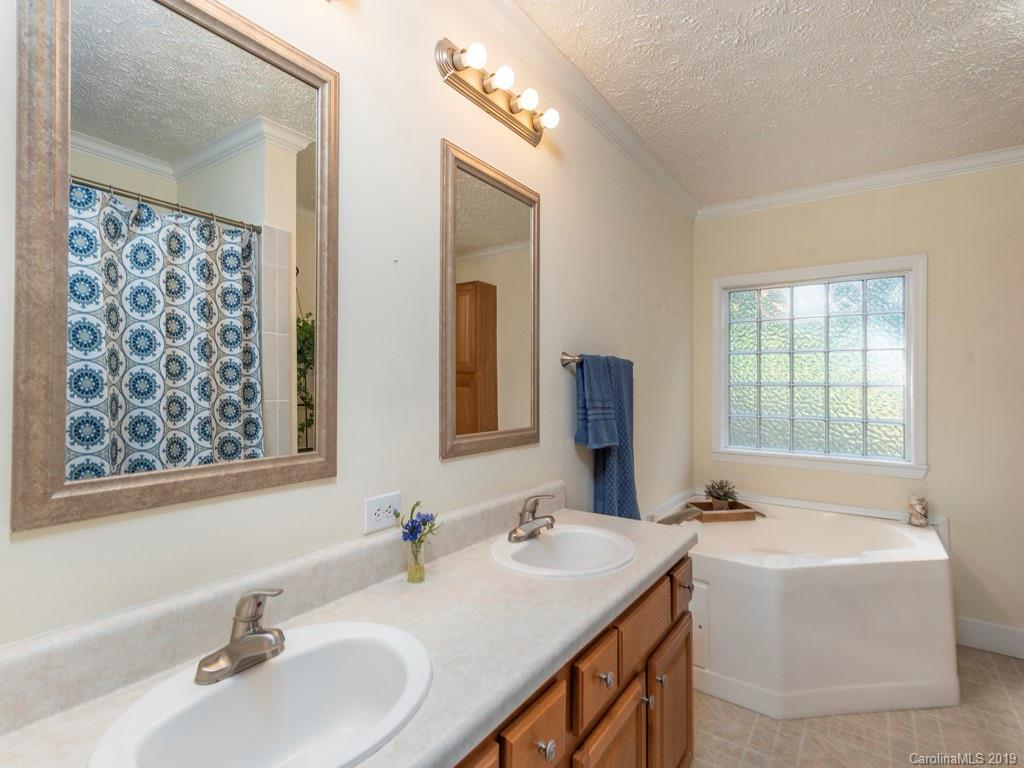 2488 Thickety Road Clyde, NC 28721 - Photo 14 of 25 a bathroom with double vanity sinks double vanity tub and a mirror