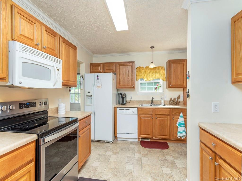 2488 Thickety Road Clyde, NC 28721 - Photo 6 of 25 a kitchen with granite countertop a refrigerator stove top oven and sink