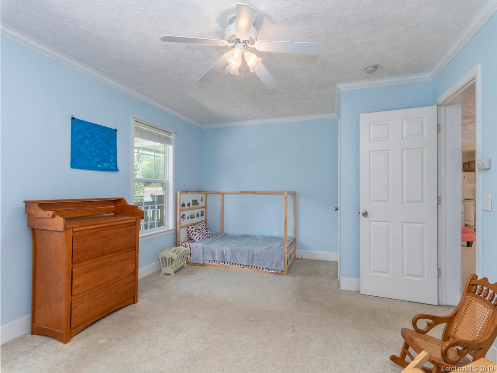 2488 Thickety Road Clyde, NC 28721 - Photo 10 of 25 a bedroom with a bed and a chandelier