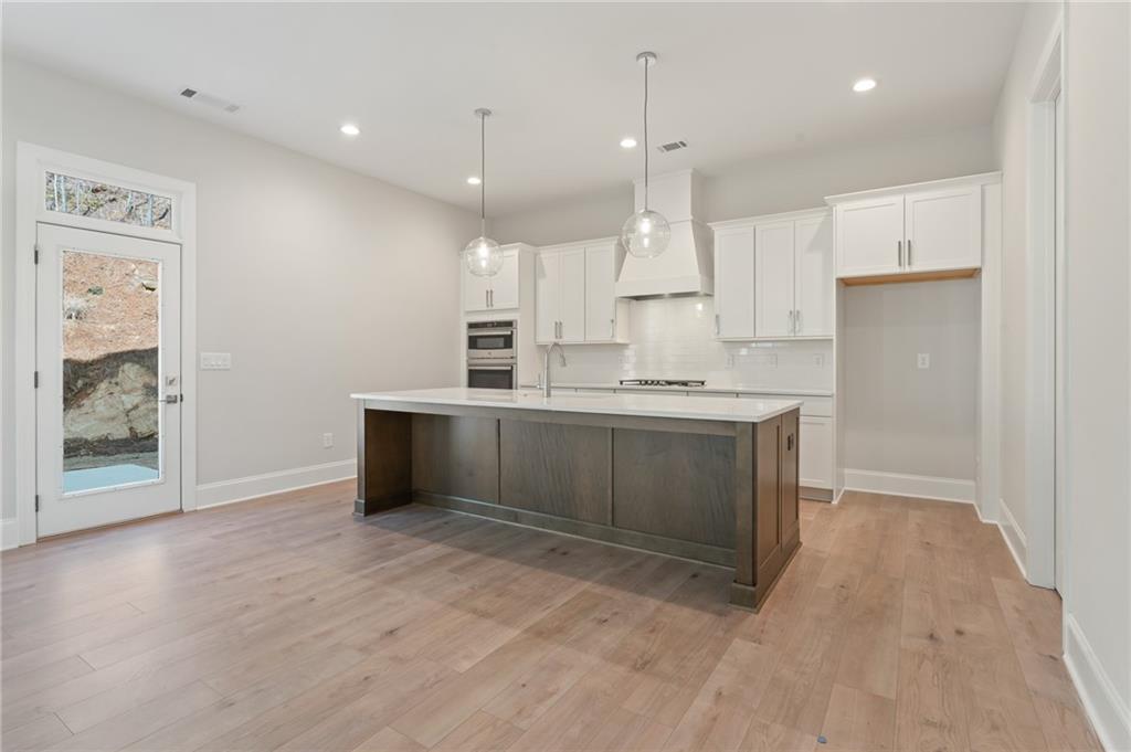 a kitchen with stainless steel appliances kitchen island a sink a stove a refrigerator and cabinets