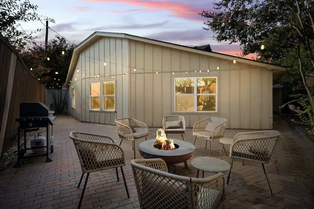 a patio with table and chairs and potted plants