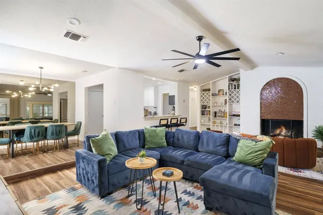 a living room with furniture a ceiling fan a rug and a chandelier