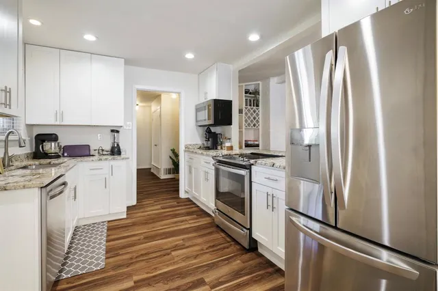 a kitchen with white cabinets and stainless steel appliances