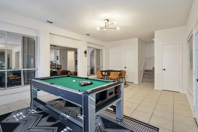 a room with pool table and window