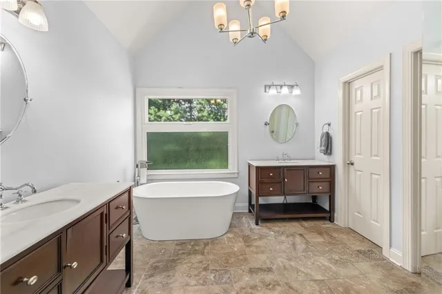 a bathroom with a tub sink and mirror