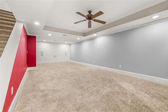 an empty room with ceiling fan and window
