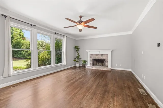 a view of an empty room with a fireplace and a window