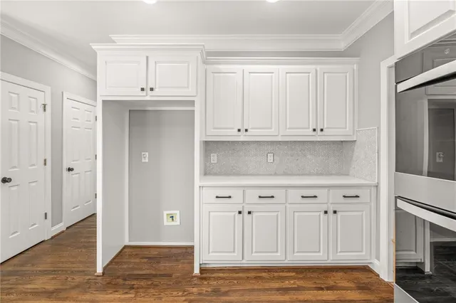 a view of kitchen with granite countertop white cabinets and stainless steel appliances