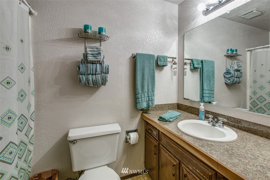 3776 Magrath Road Bellingham, WA 98226 - Photo 12 of 23 a bathroom with a granite countertop sink toilet and a mirror
