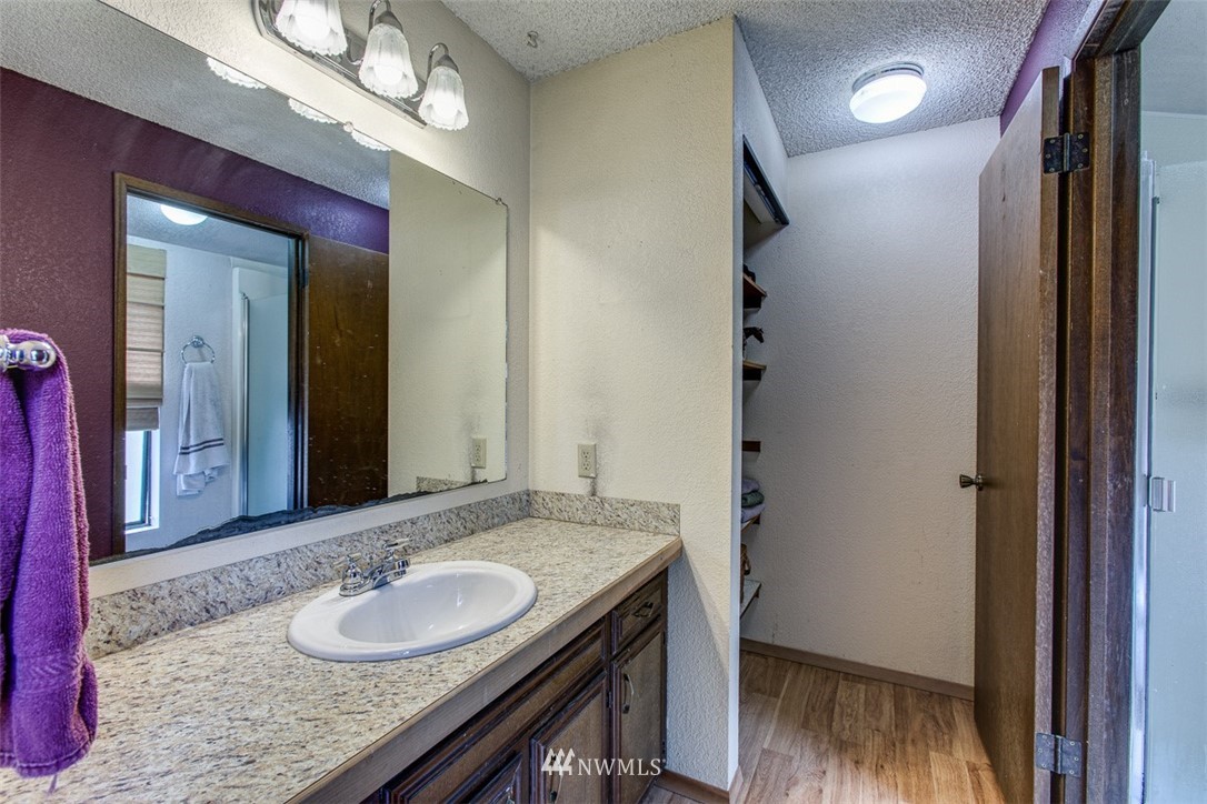 3776 Magrath Road Bellingham, WA 98226 - Photo 17 of 23 a bathroom with a granite countertop sink a light fixture and a mirror