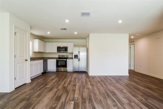 a view of kitchen with wooden floor and electronic appliances
