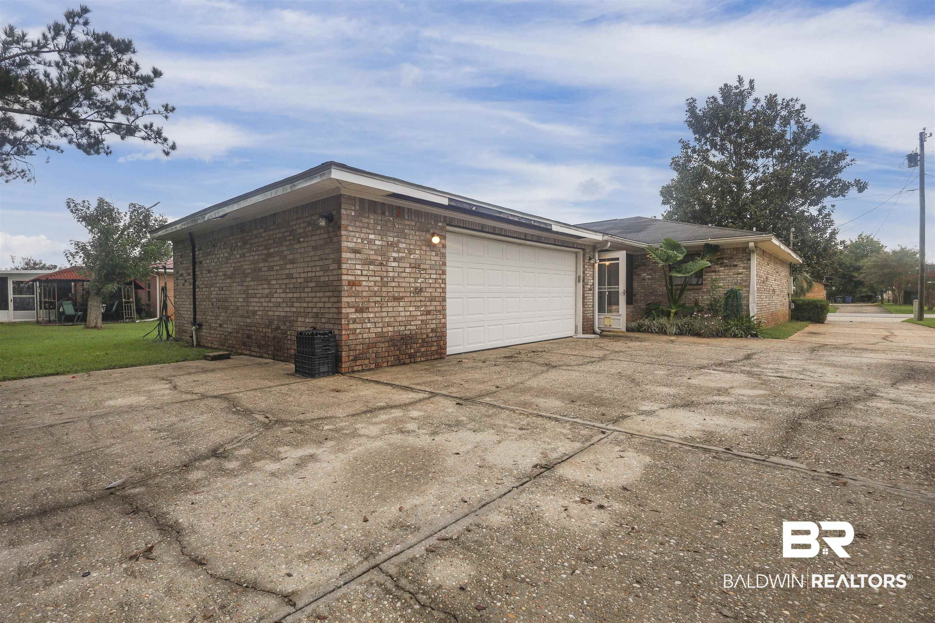 507 West Amanda Avenue Foley, AL 36535 - Photo 22 of 23 View of property exterior with a garage and a lawn