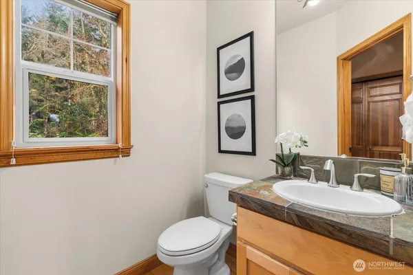 a bathroom with a granite countertop toilet sink and mirror