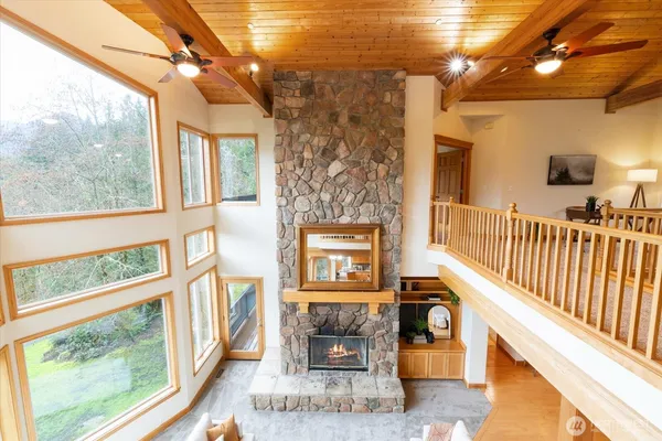 a living room with large windows and a fireplace